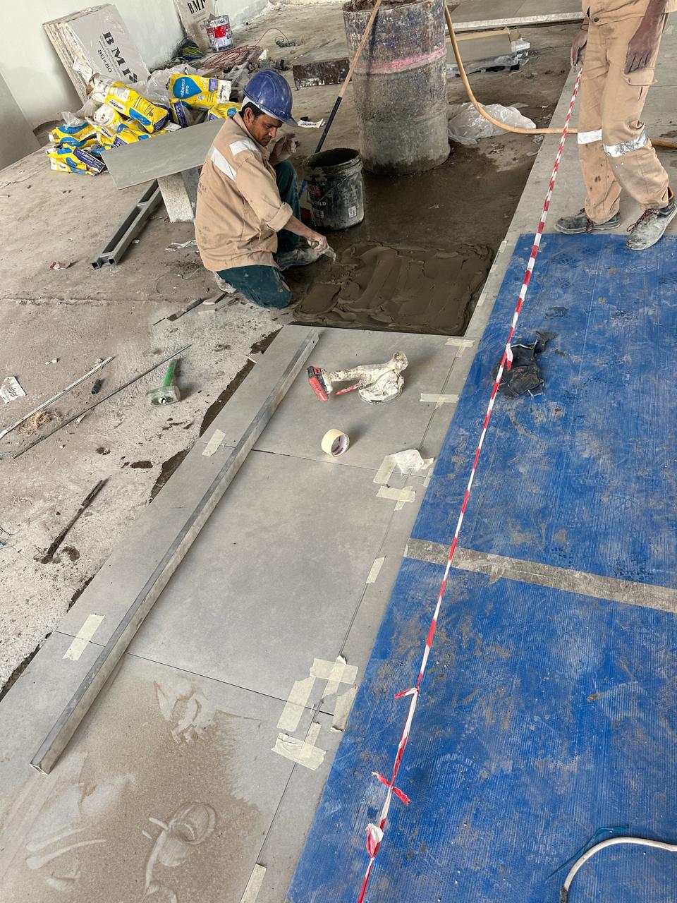 SpaceForge craftsman preparing a subfloor for large-format stone tile installation on a luxury residential project in Dubai