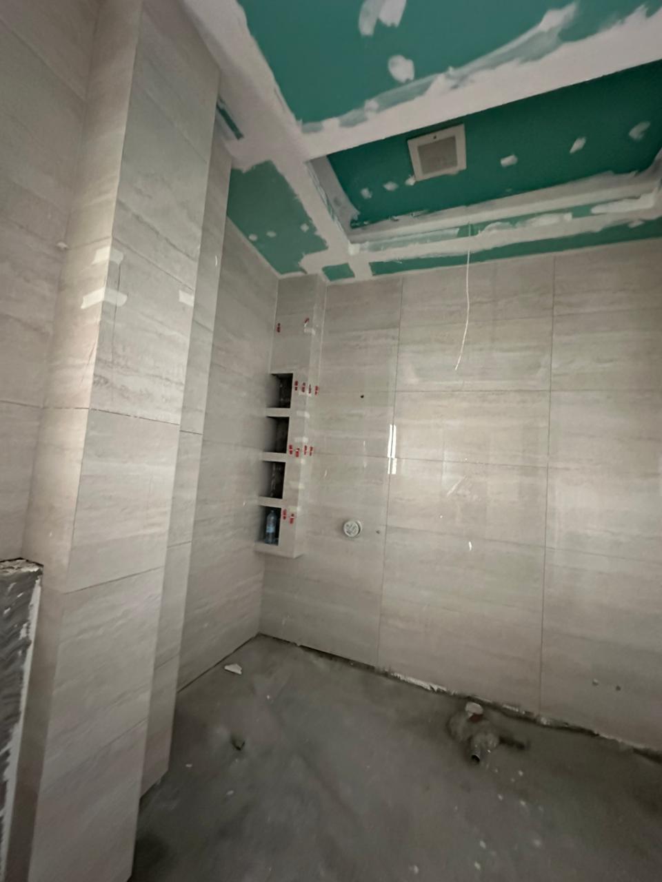 SpaceForge tiling fit-out Dubai, large-format wall tiles installed in a luxury residential bathroom in progress