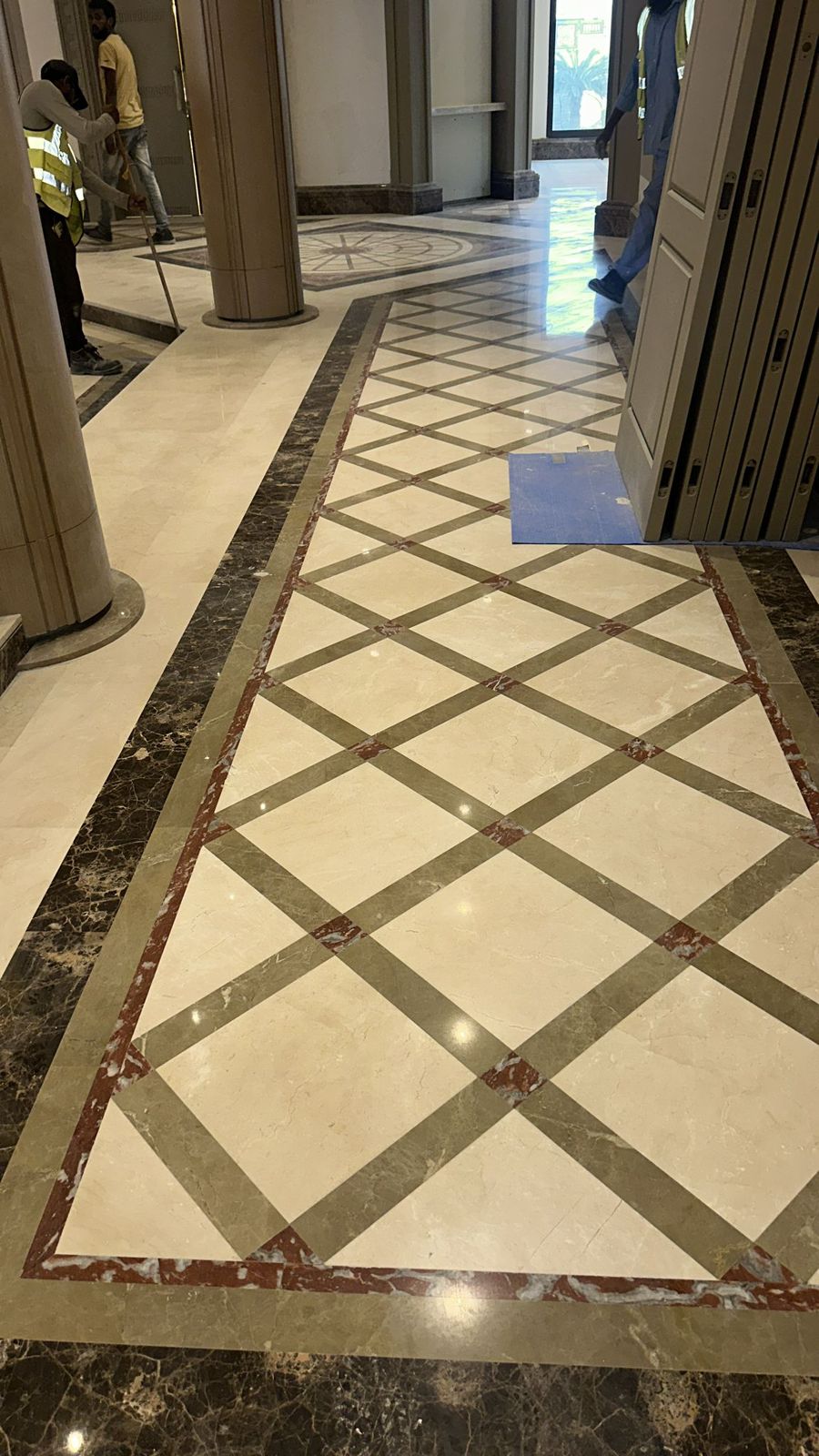 SpaceForge tiling service Dubai, bespoke multi-tone marble floor pattern with inlay border detail in a luxury lobby