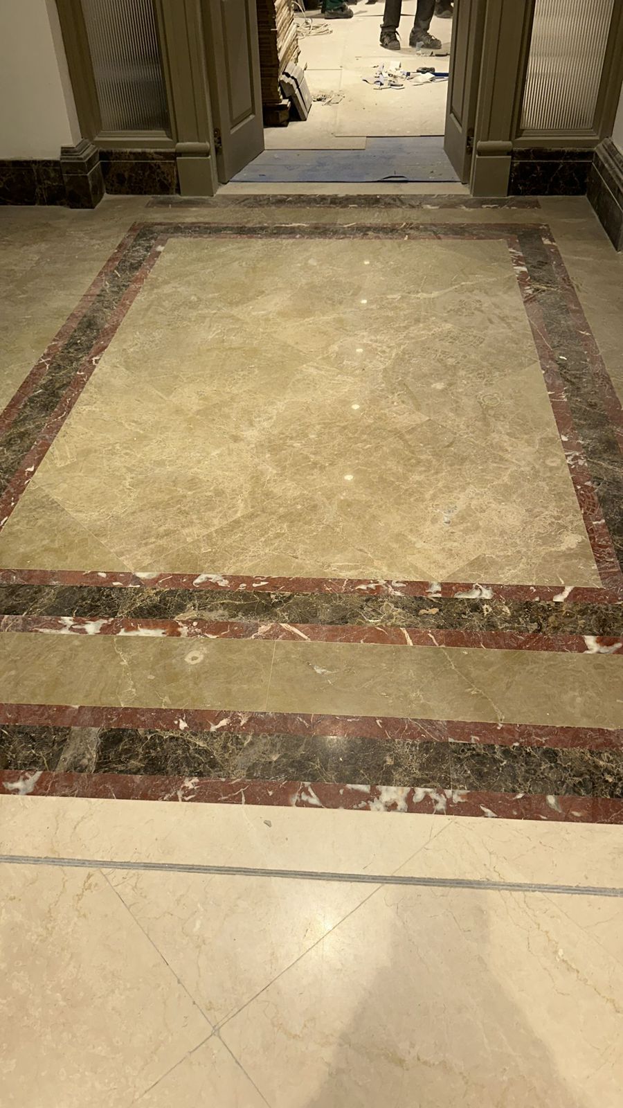 SpaceForge precision tiling Dubai, multi-tone marble floor border installation in a luxury villa entrance hall