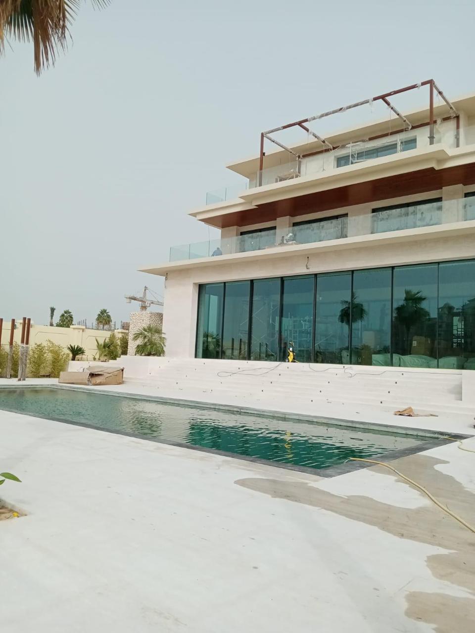 SpaceForge luxury villa fit-out Dubai, exterior facade with floor-to-ceiling glazing and a completed lap pool