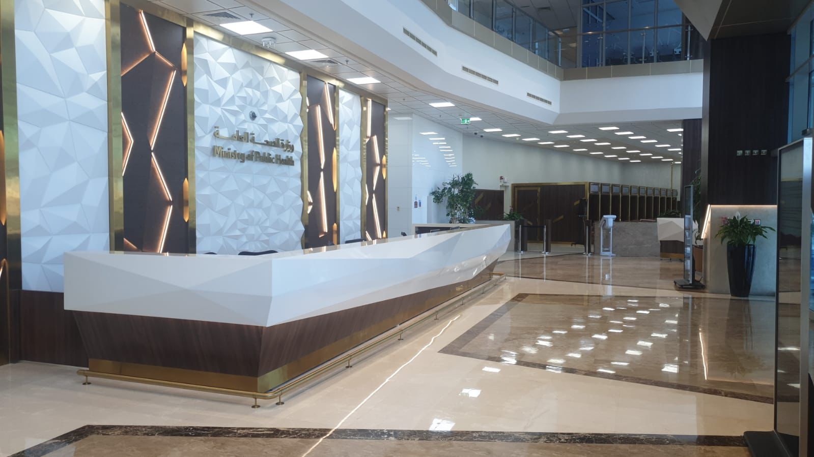 SpaceForge commercial fit-out Dubai, grand reception lobby with curved bespoke desk, marble flooring, decorative columns, and glazed ceiling